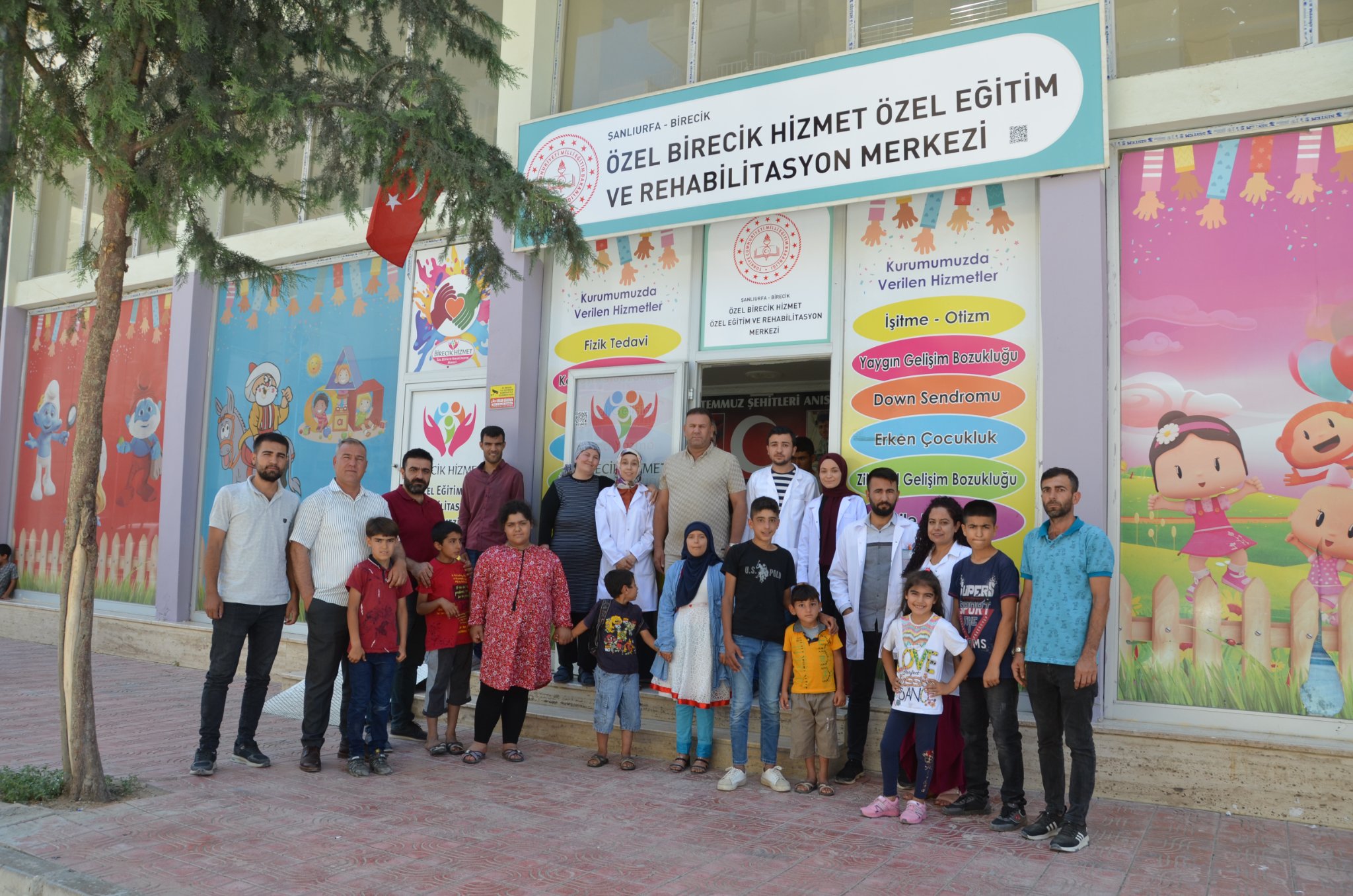 Bir 14 kişi, ayakta duran insanlar ve şunu diyen bir yazı 'ŞANLIURFA HİZMET ÖZEL EĞİTİM MERKEZİ M VE ÖZEL REHABİLİTASYON BİRECİK -BİRECİK Kurumumuzda Verilen Hizmetler REAB Fizik Tedavi Kurumumuzda Verilen Hizmetler İşitme Otizm Yaygın Gelişim Bozukluğu Down Sendromu Erken Çocukluk Gelişim Bozukluğu PER SANCS' görseli olabilir